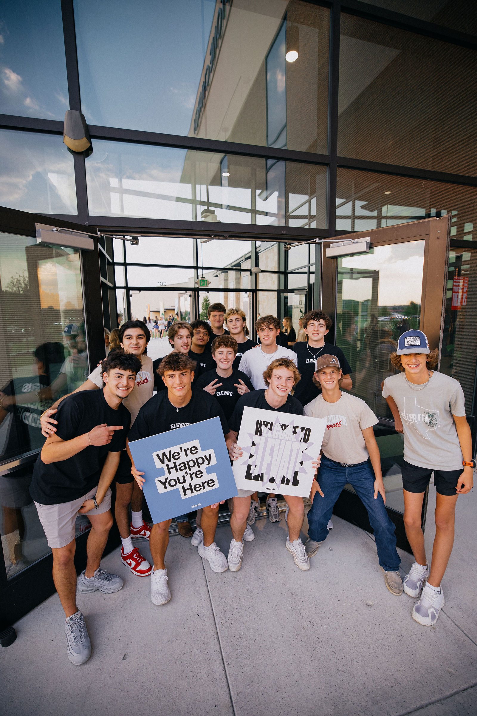 Students at the Elevate entrance holding a We&rsquo;re Happy You&rsquo;re Here sign