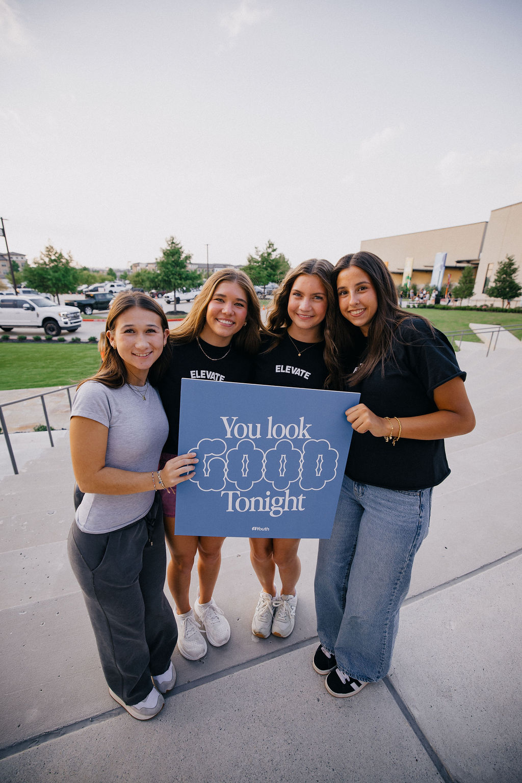 Elevate serve team students holding welcome signs